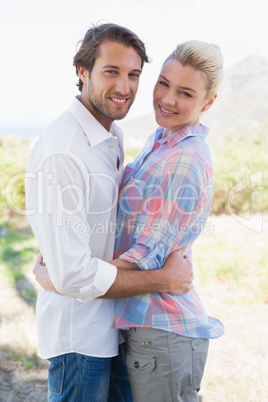 Cute couple standing hugging and smiling at camera