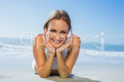 Fit smiling woman lying on the beach