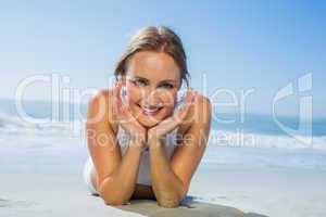 Fit smiling woman lying on the beach