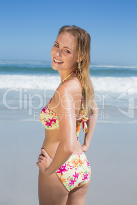 Smiling fit woman in floral bikini at beach