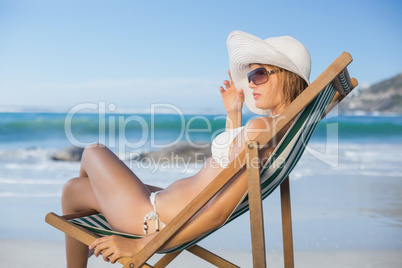 Pretty woman relaxing in deck chair on the beach