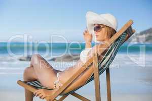 Pretty woman relaxing in deck chair on the beach