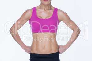 Female bodybuilder posing in pink sports bra and shorts mid sect