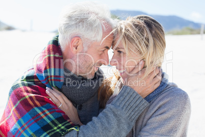 Happy married couple embracing on the beach