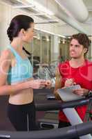 Trainer talking to his client on the treadmill