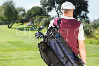 Golfer carrying his golf bag