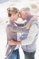 Happy hugging couple on the beach looking at each other