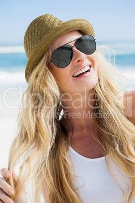 Stylish blonde smiling on the beach