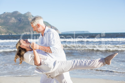 Happy couple dancing on the beach together