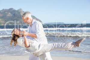 Happy couple dancing on the beach together