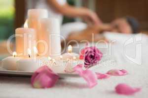 Candles and rose petals on massage table
