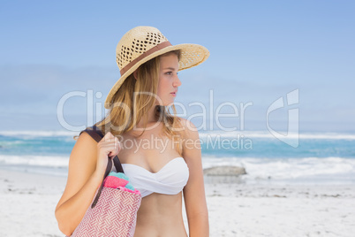 Beautiful blonde on the beach holding bag