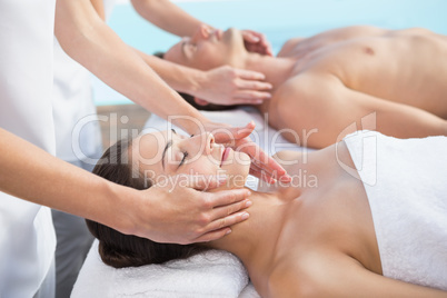 Peaceful couple enjoying couples massage poolside