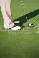 Golfer putting ball on the green