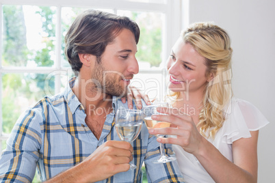 Cute smiling couple enjoying white wine together