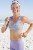 Sporty blonde jogging on the beach