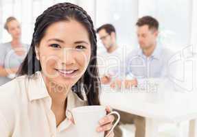Casual businesswoman smiling at camera during meeting