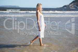 Woman in white dress walking in the sea