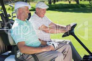 Golfing friends laughing together in their golf buggy