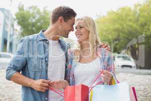 Hip young couple looking at their shopping bags