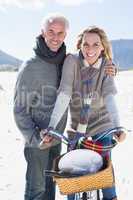 Carefree couple going on a bike ride and picnic on the beach