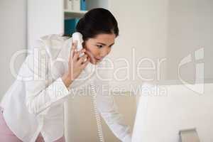 Casual asian businesswoman answering the telephone