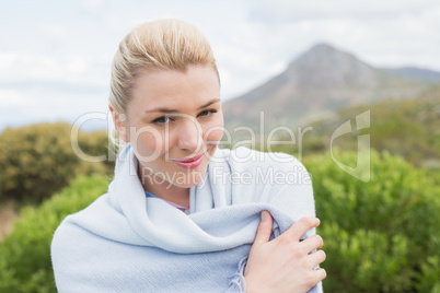 Pretty blonde wrapped up in blanket outside