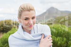 Pretty blonde wrapped up in blanket outside