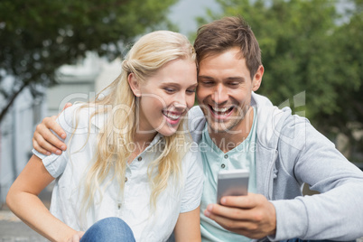 Hip young couple looking at smartphone