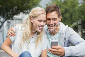 Hip young couple looking at smartphone