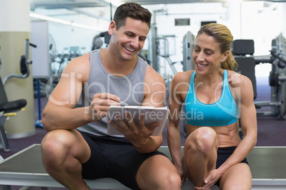 Female bodybuilder sitting with personal trainer talking