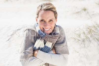 Attractive shivering blonde standing on the beach