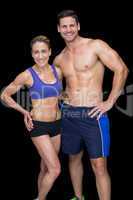 Crossfit couple smiling at camera with hands on hips