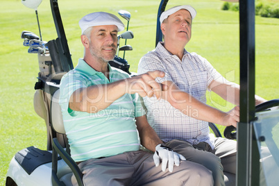 Golfing friends driving in their golf buggy