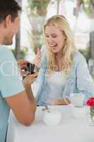 Man proposing marriage to his shocked blonde girlfriend