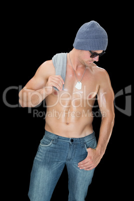 Muscular man posing in blue jeans hat and sunglasses