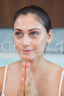 Peaceful woman in white sitting with hands together