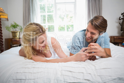 Cute couple relaxing on bed laughing together