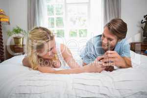 Cute couple relaxing on bed laughing together