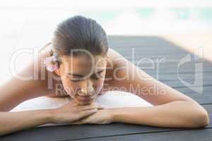 Calm brunette lying on a towel poolside