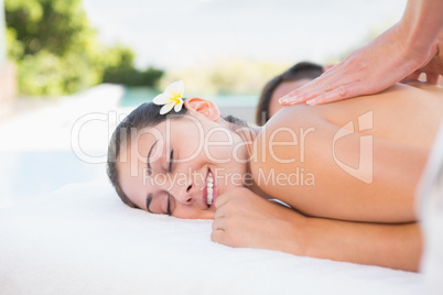 Attractive couple enjoying couples massage poolside