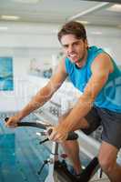 Smiling fit man on the spin bike