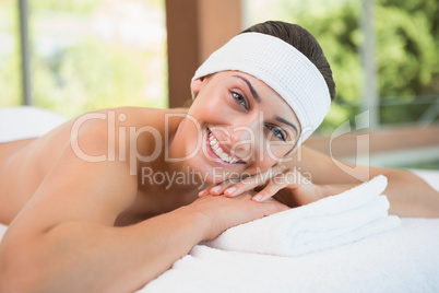 Beautiful smiling brunette lying on massage table