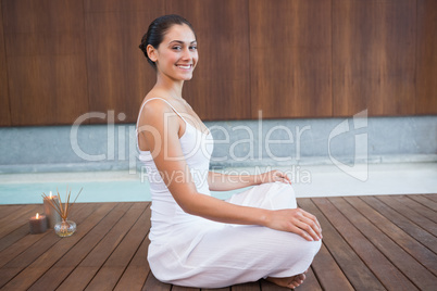 Content brunette in white sitting in lotus pose