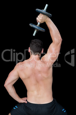 Strong crossfitter lifting up heavy black dumbbell above head