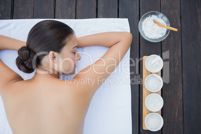 Peaceful brunette lying poolside on towel