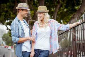 Hip young couple standing by railings