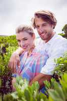 Smiling couple embracing outside among the bushes