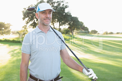 Smiling handsome golfer looking ahead