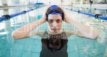 Fit swimmer in the pool smiling at camera